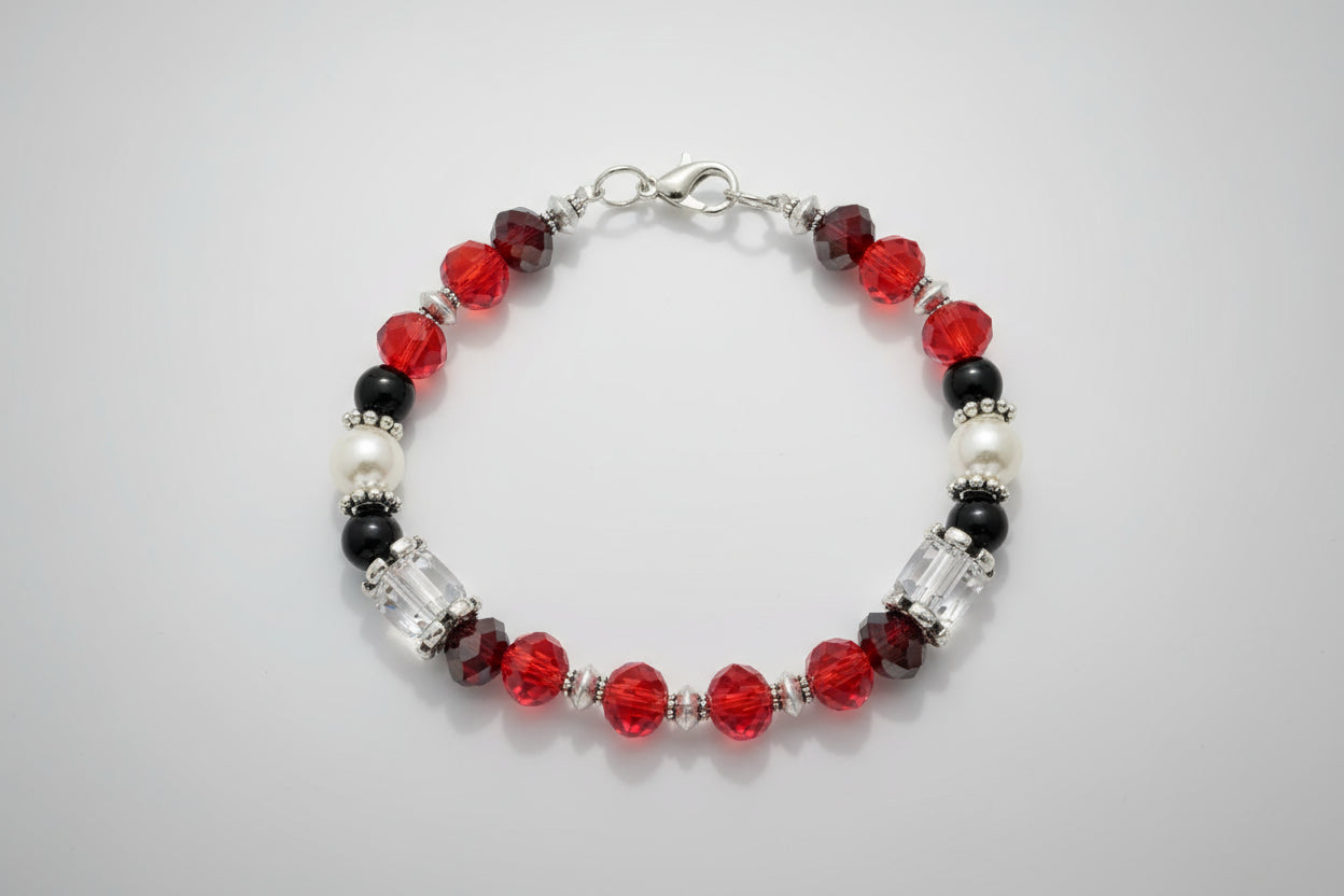 Beaded bracelet with red, black, and clear beads on a dark background