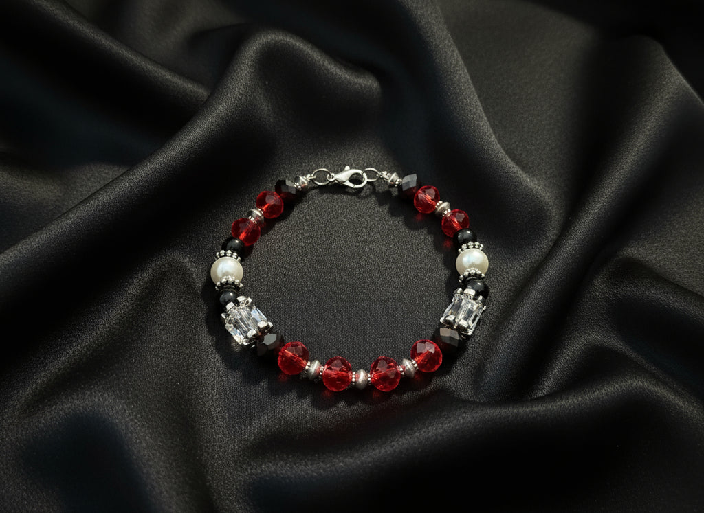 Beaded bracelet with red, black, and clear beads on a dark textured background