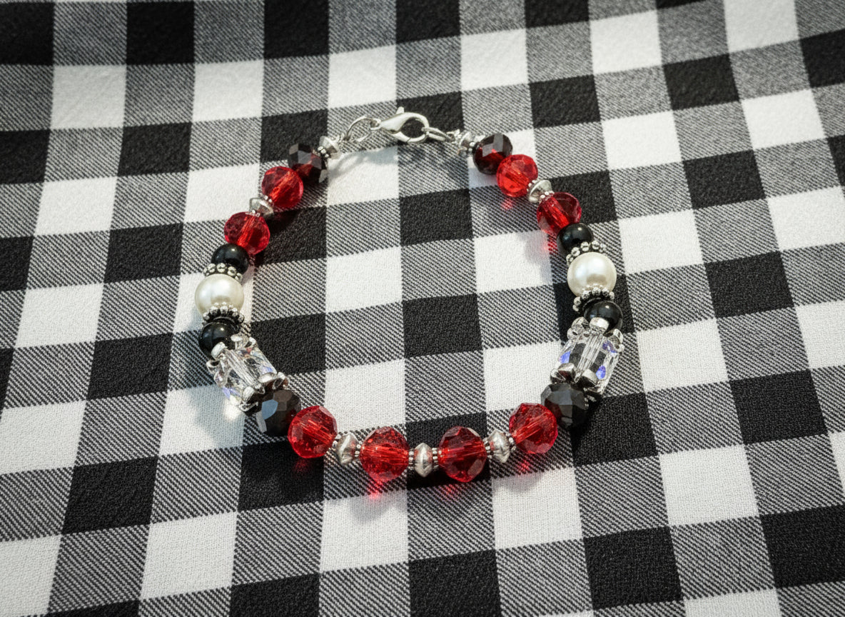 Beaded bracelet with red, black, and white beads on a dark textured background