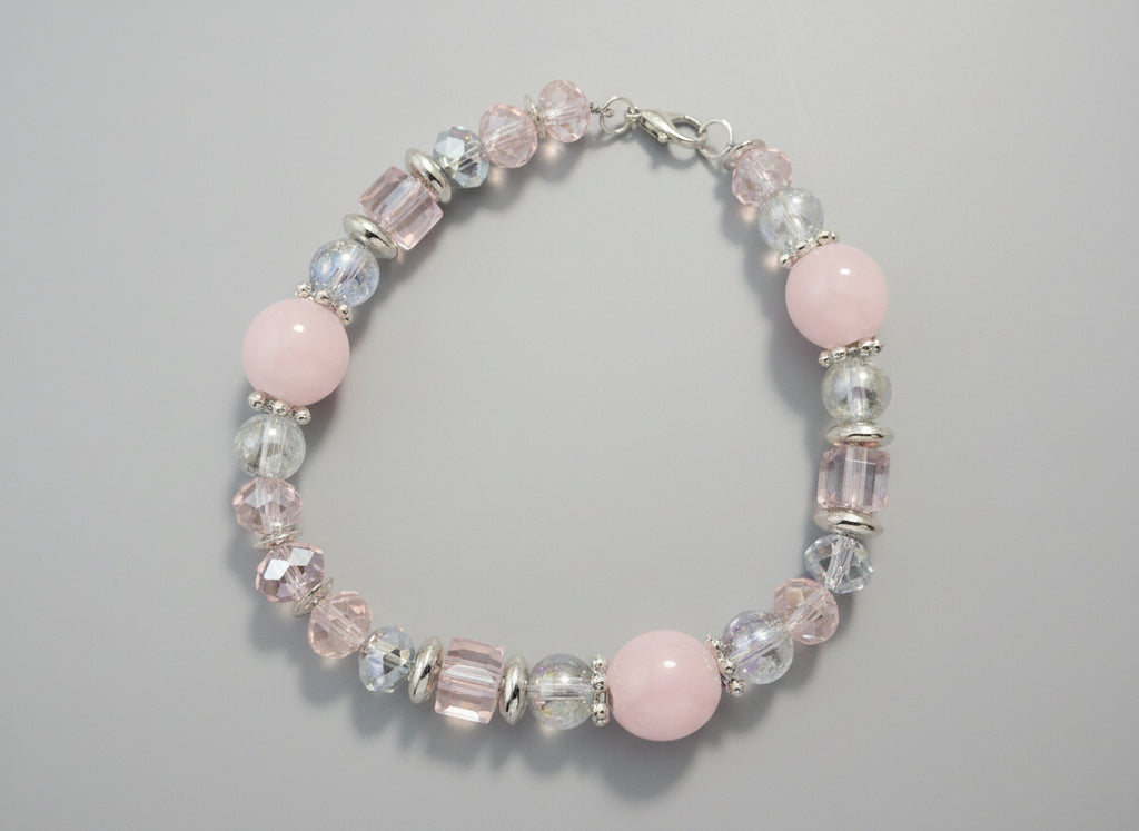 Beaded bracelet with pink and clear beads on a black background