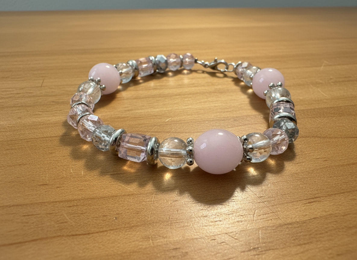 Beaded bracelet with pink and clear beads on a black background