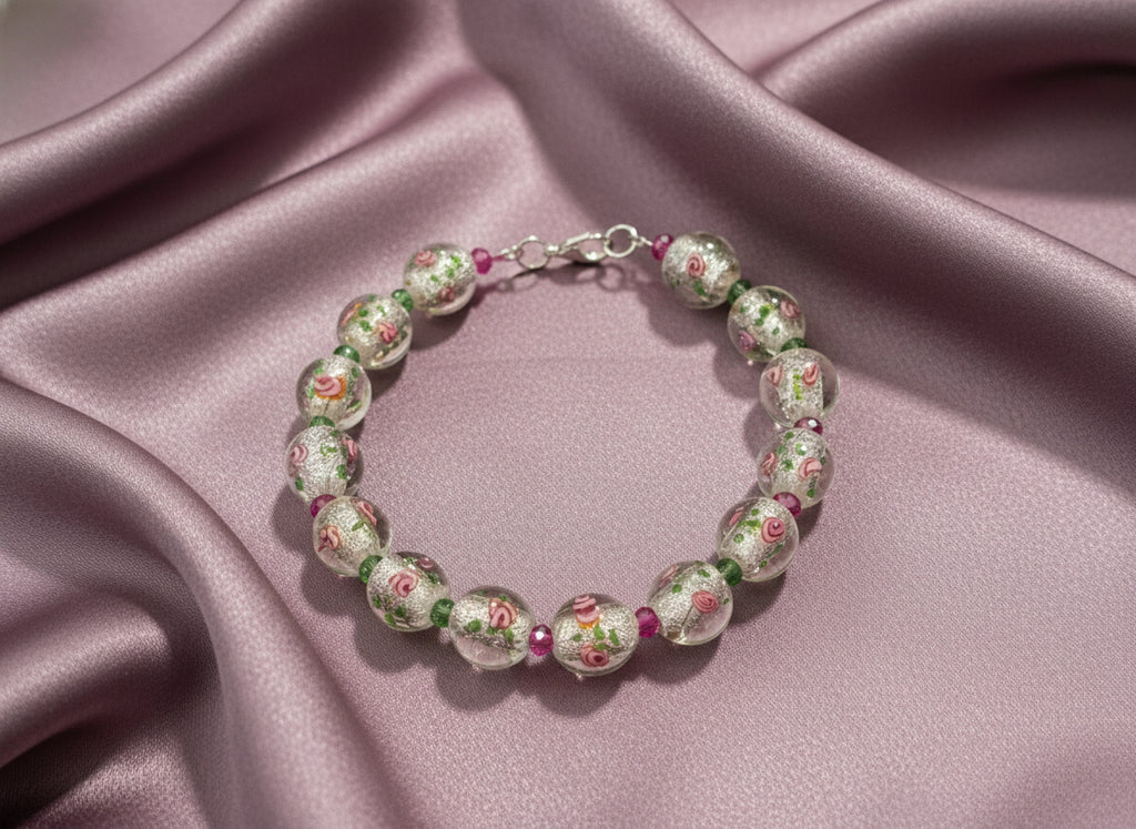 Beaded bracelet with floral designs on clear beads against a black background