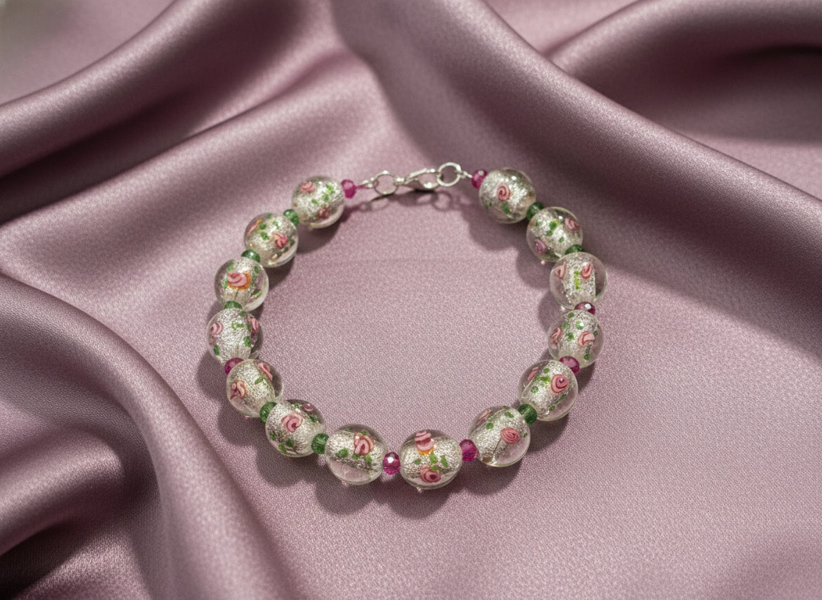 Beaded bracelet with floral designs on clear beads against a black background