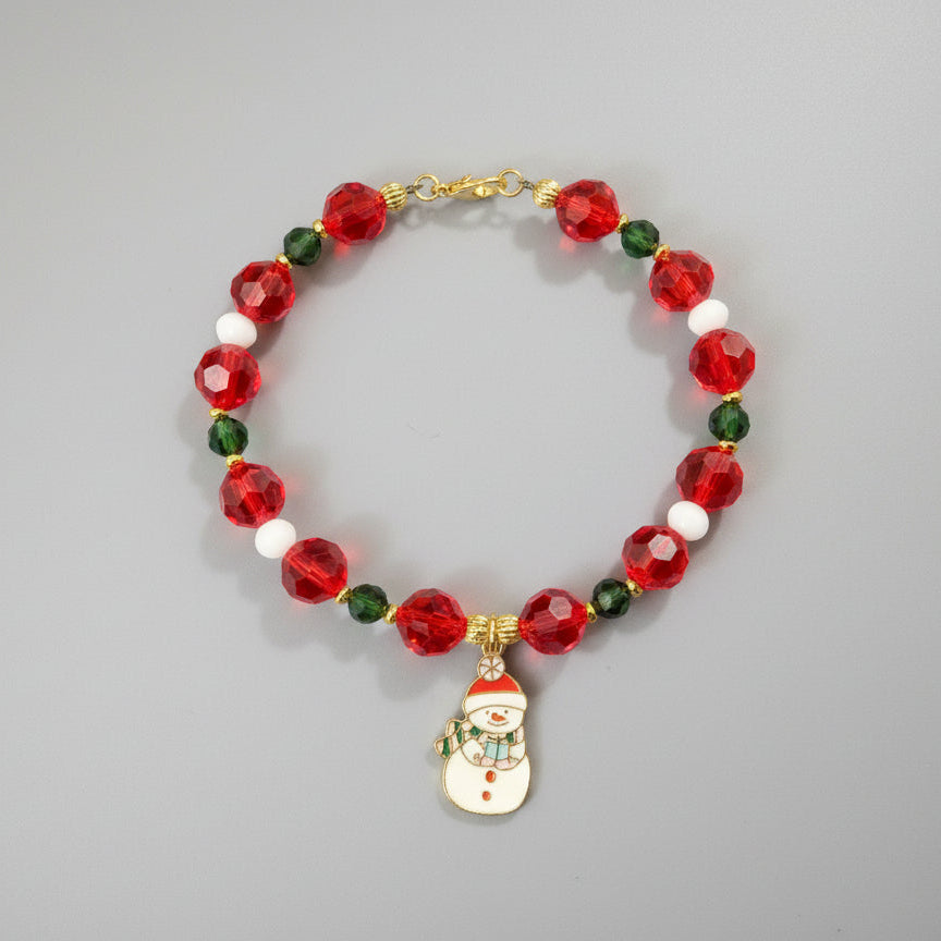 Bracelet with red beads and a snowman charm on a black background