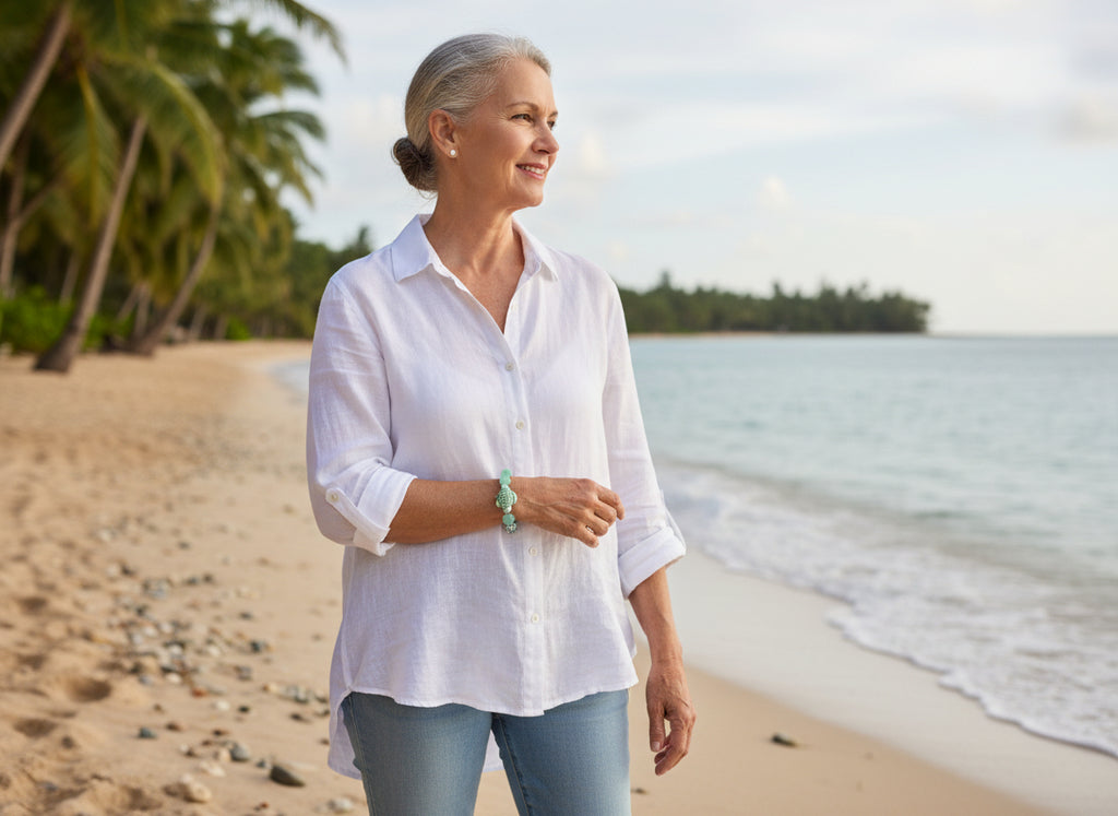 Bracelet with green and pink beads and a turtle charm on a dark background