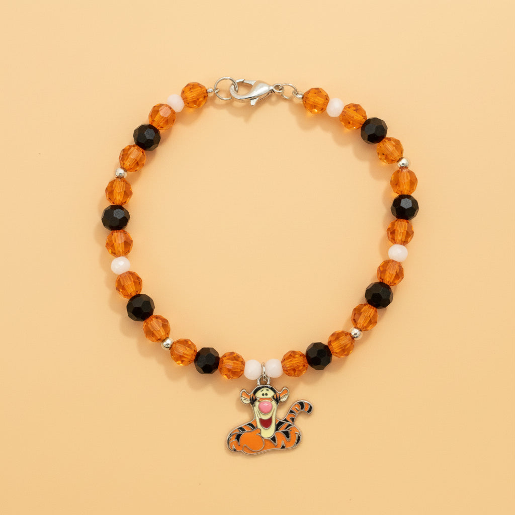 Beaded bracelet with a small charm on a dark background