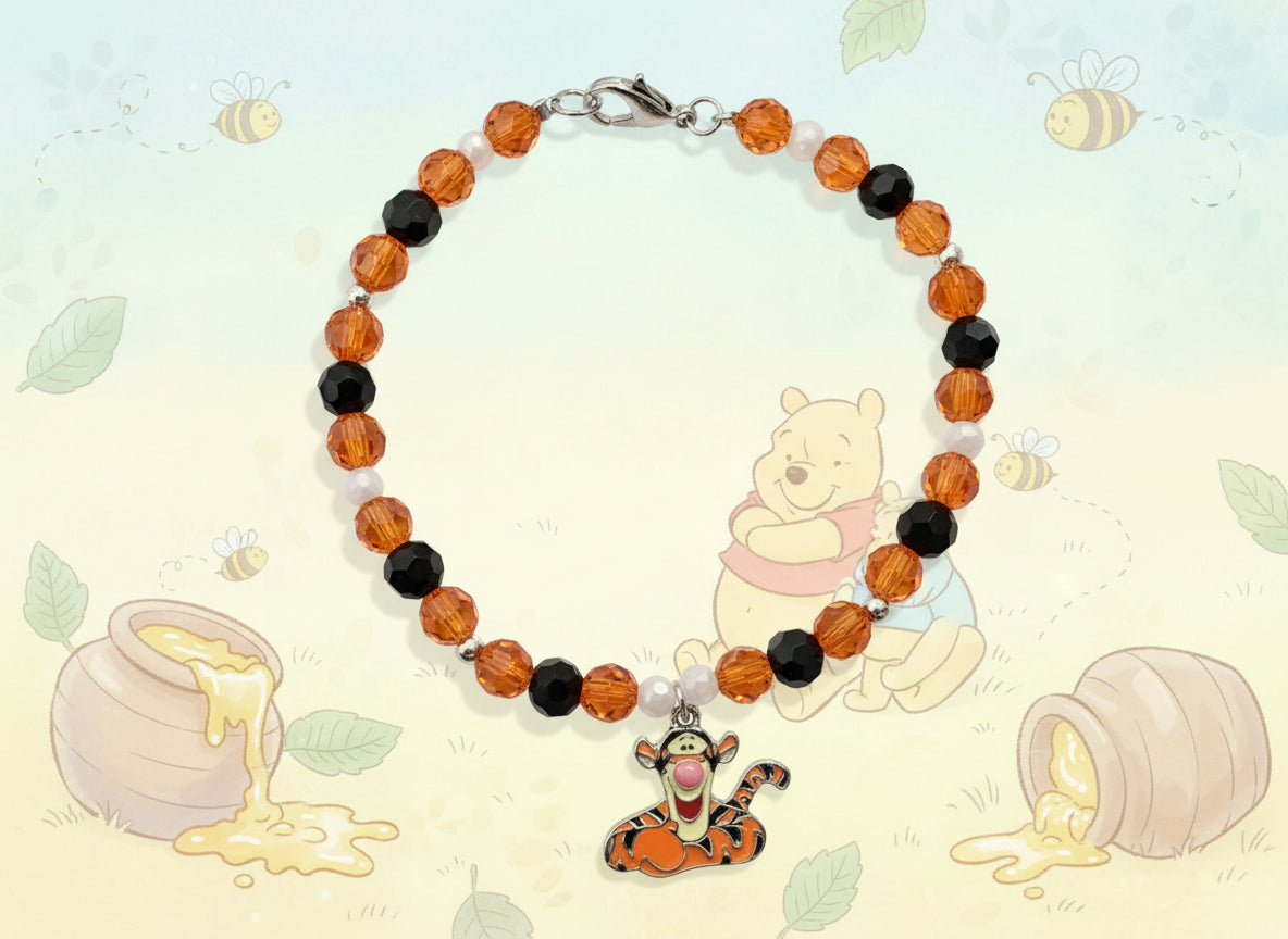 Bracelet with orange, black, and white beads and a cartoon character charm on a dark background