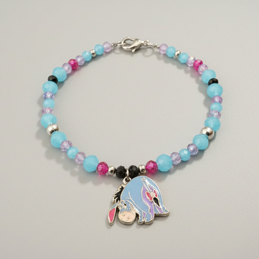 Bracelet with colorful beads and a charm on a dark background