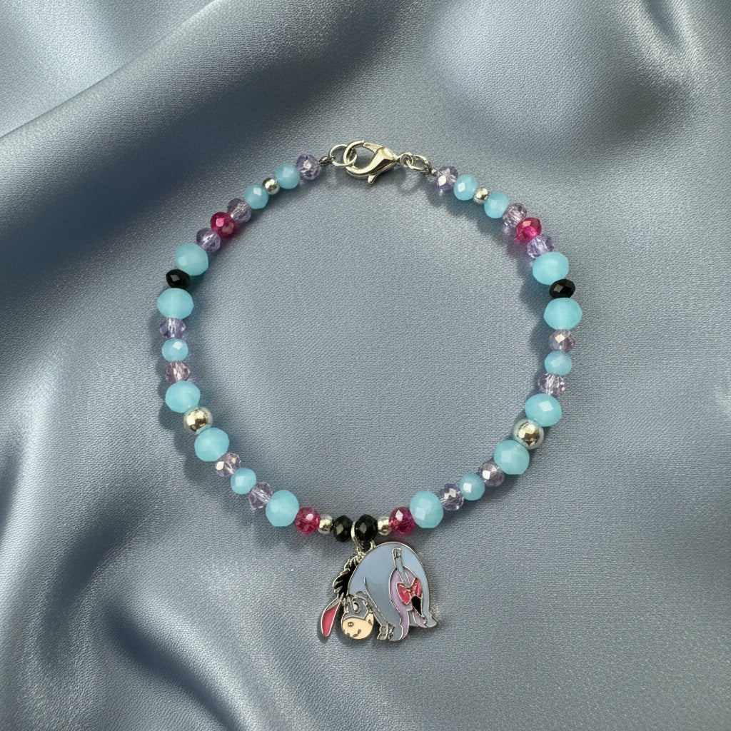 Beaded bracelet with a hamsa hand charm on a brown background