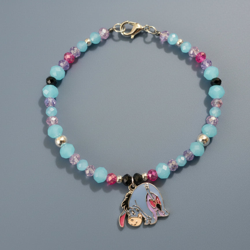 Beaded bracelet with a charm on a brown background