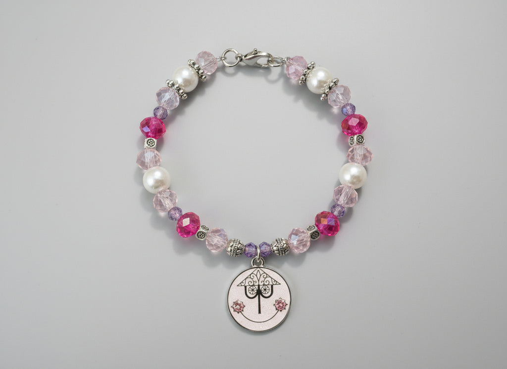 Beaded bracelet with a circular charm on a black background