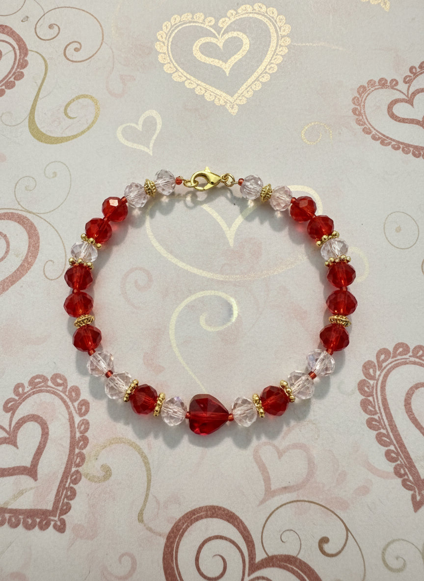Beaded bracelet with red and clear beads on a dark gray background