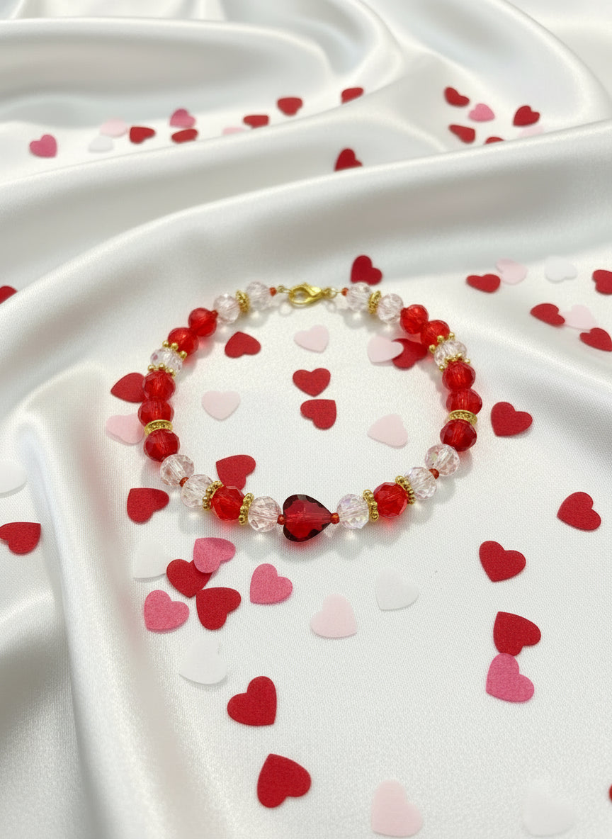 Bracelet with red, clear, and gold beads on a dark textured background