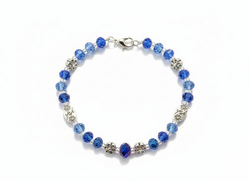 Beaded bracelet with blue and silver beads on a dark background