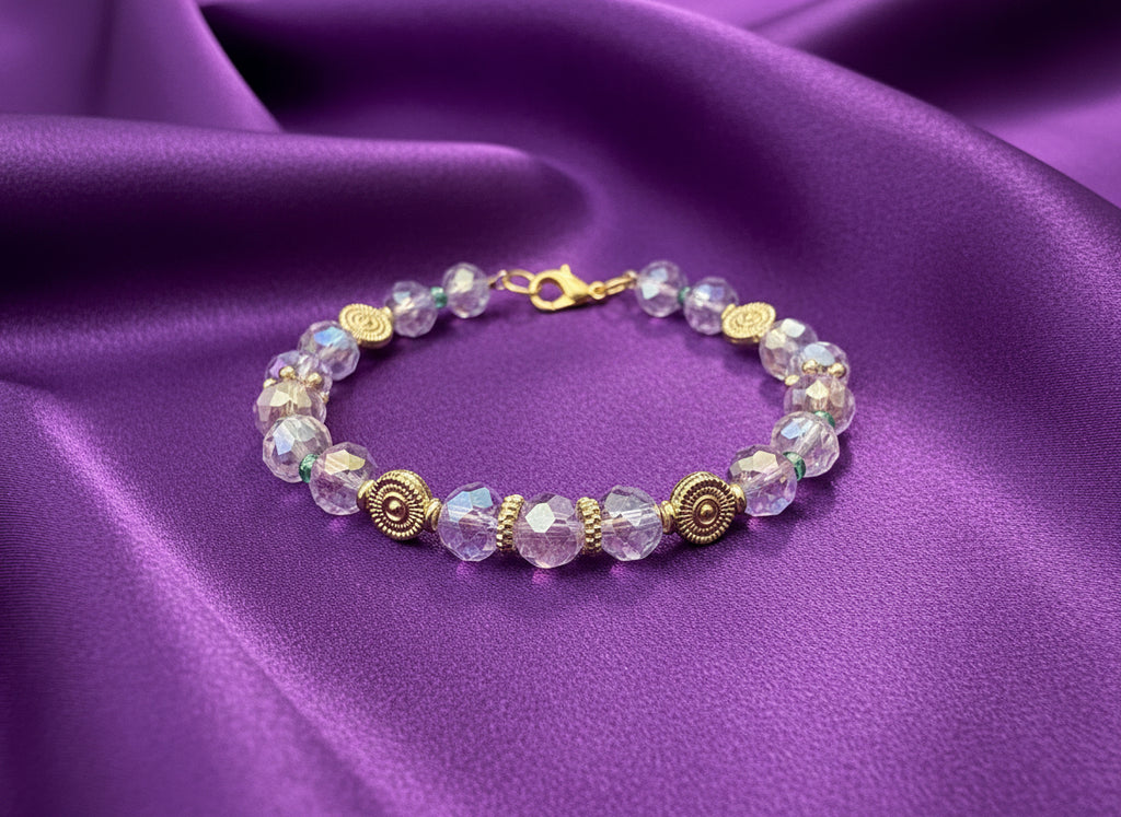 Bracelet with purple beads and gold accents on a dark textured background