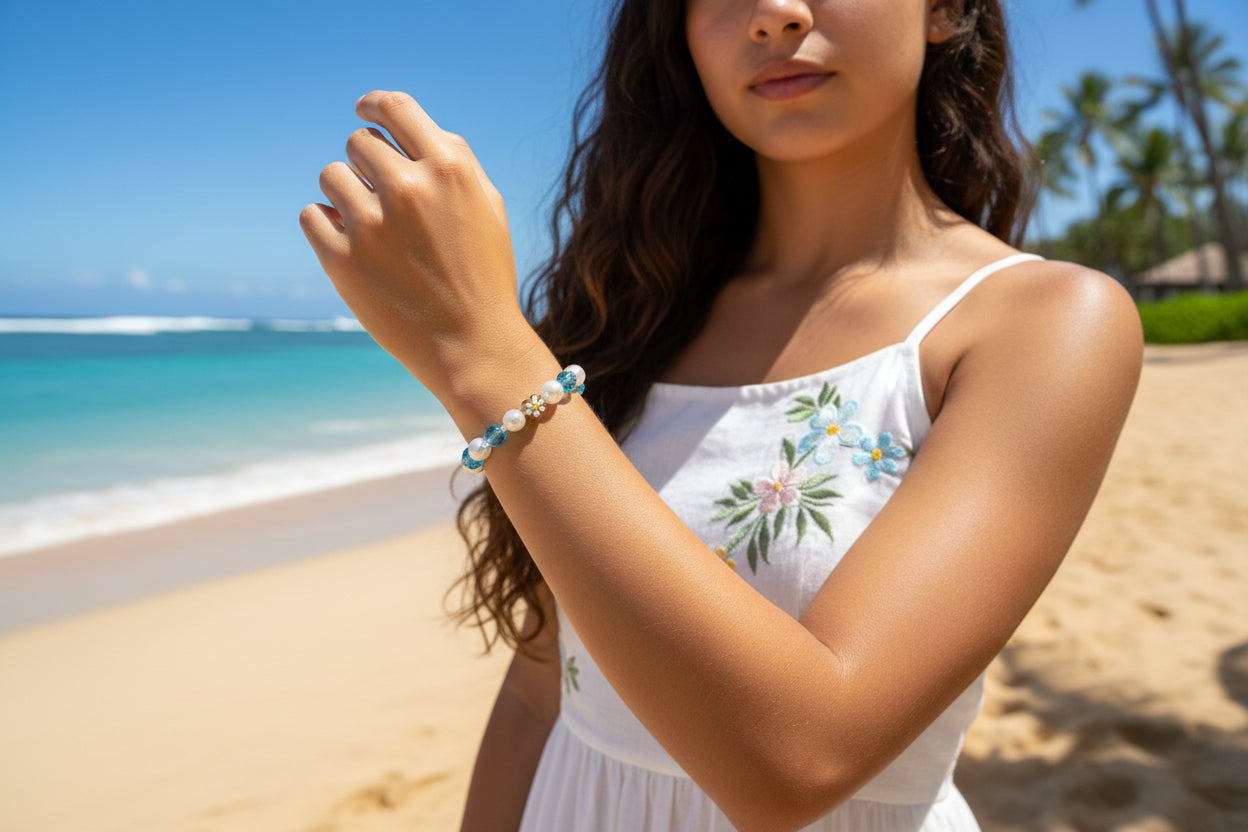 Beaded bracelet with blue and white beads and gold flowers on a dark background