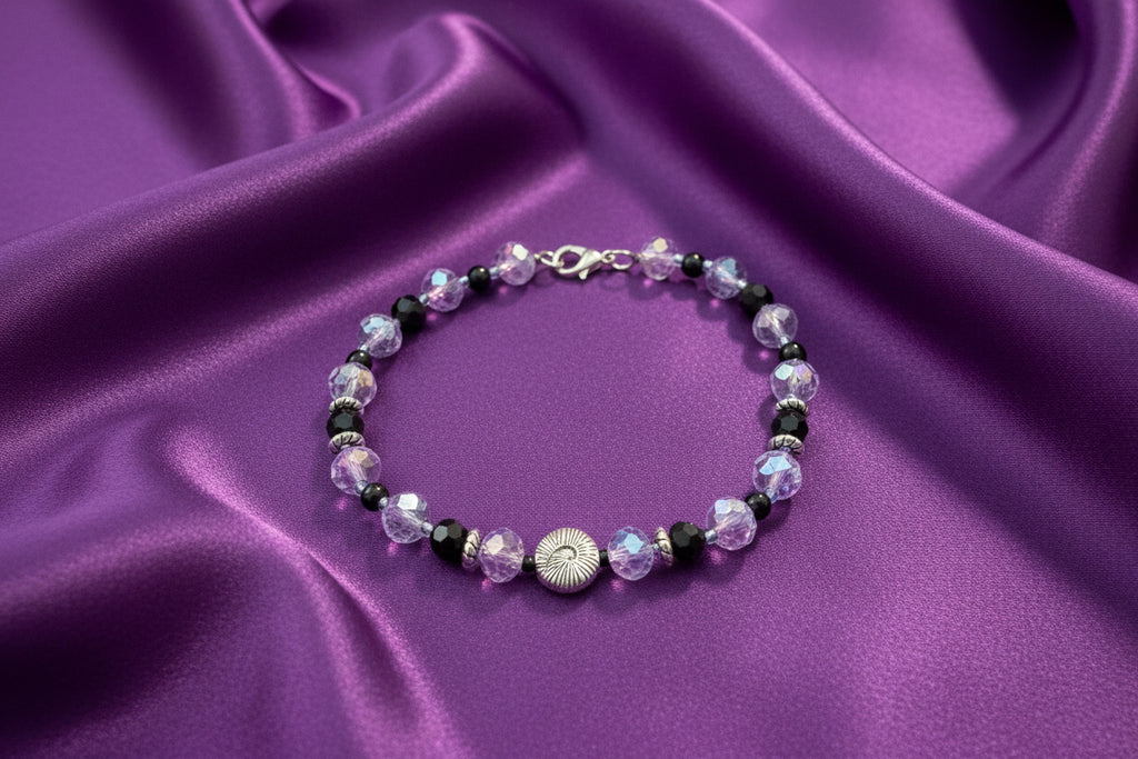 Beaded bracelet with purple and black beads on a dark background