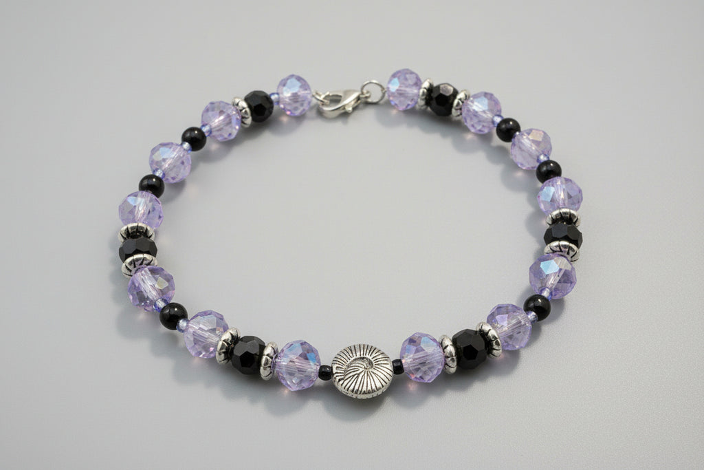 Beaded bracelet with purple and black beads on a dark background