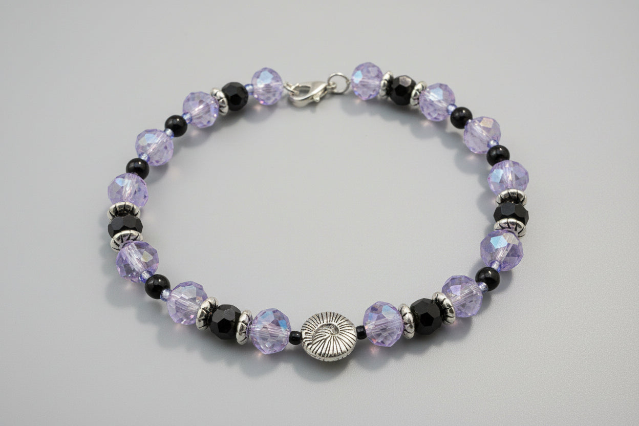 Beaded bracelet with purple and black beads on a dark background