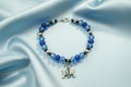 Bracelet with blue beads and R2D2 charm on a dark background
