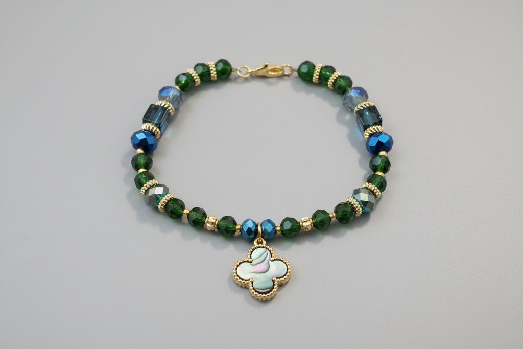 Beaded bracelet with a clover charm on a dark textured background