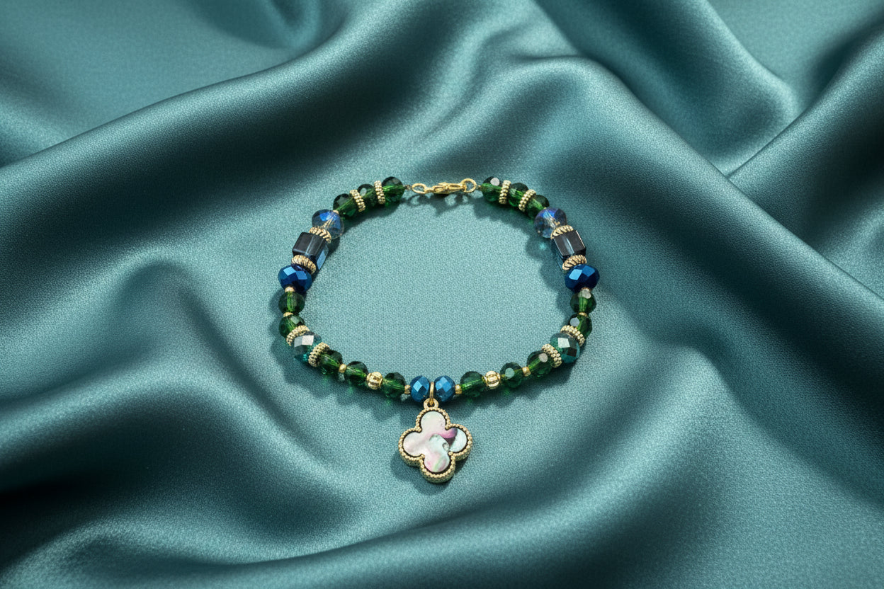 Beaded bracelet with a clover-shaped charm on a dark textured background