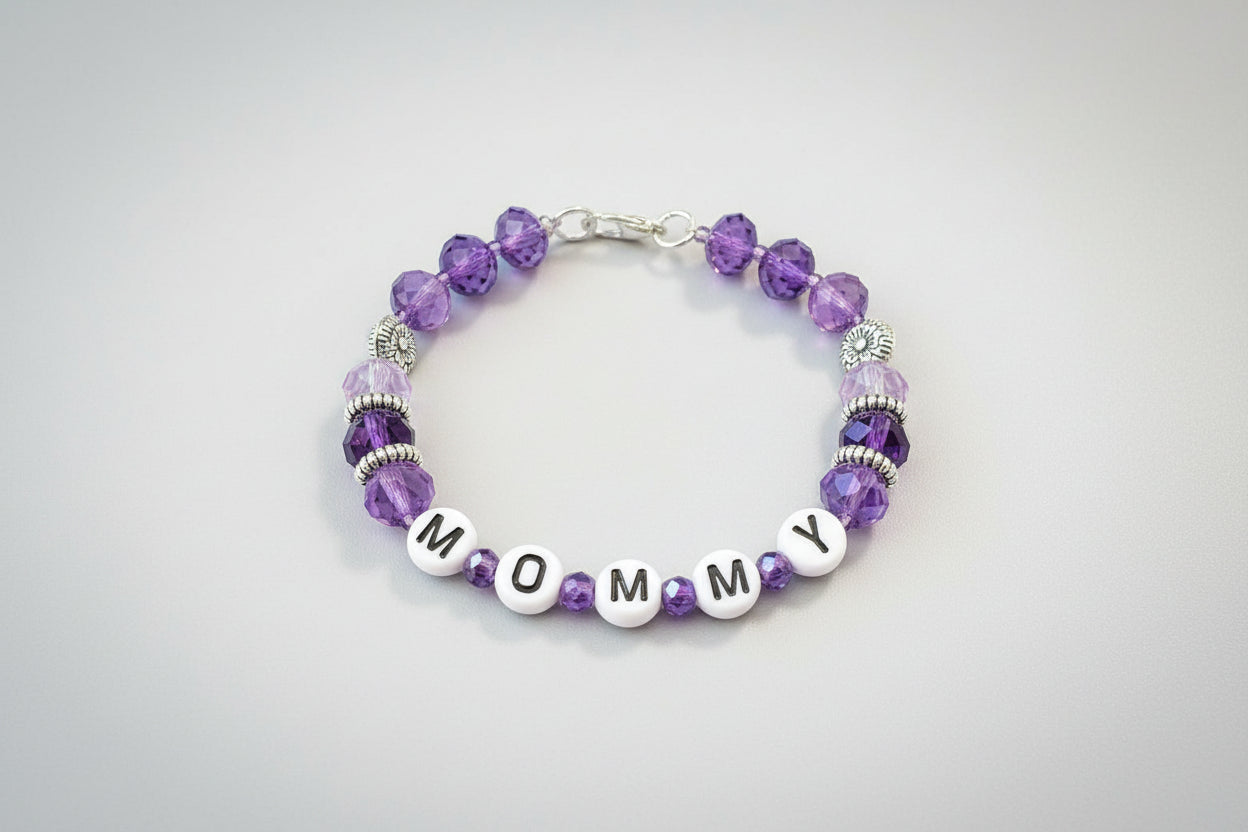Bracelet with purple beads and letter beads spelling 'MOM' on a dark background