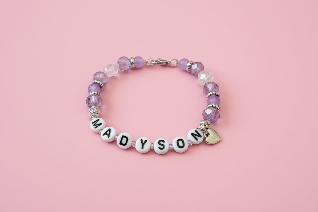 Beaded bracelet with 'MADYSON' on a dark background
