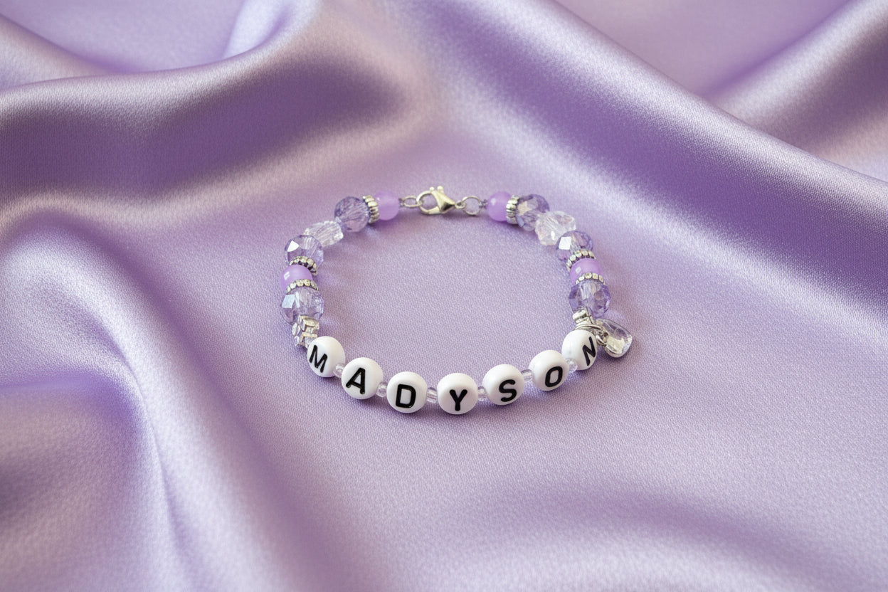 Bracelet with letter beads spelling 'MADYSON' on a dark surface