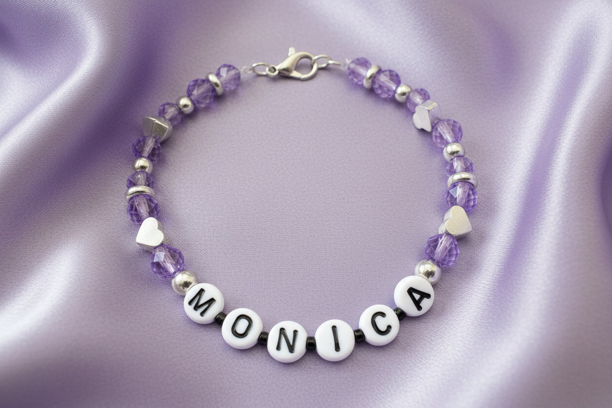 Bracelet with black and silver beads and 'MONICA' beads on a dark background