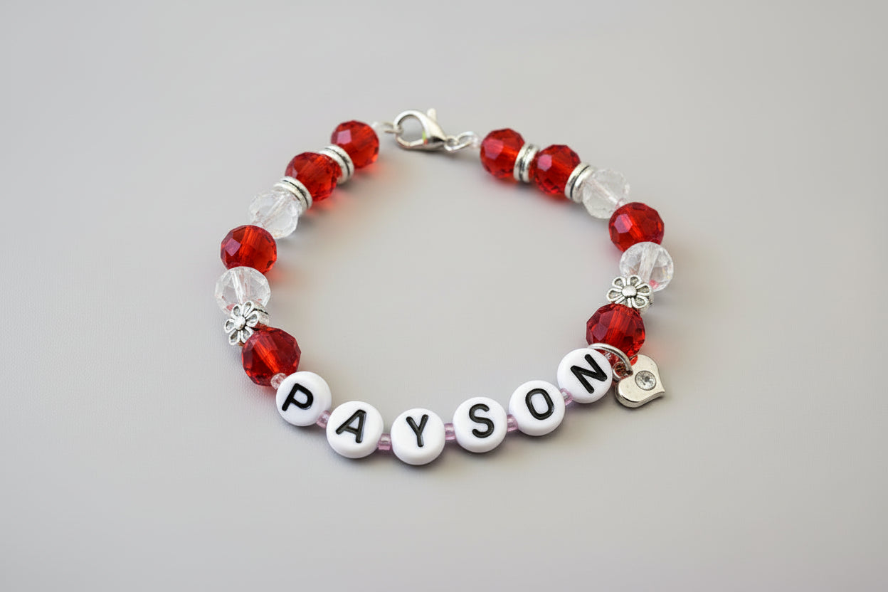 Bracelet with blue beads and personalized name charm on a dark surface