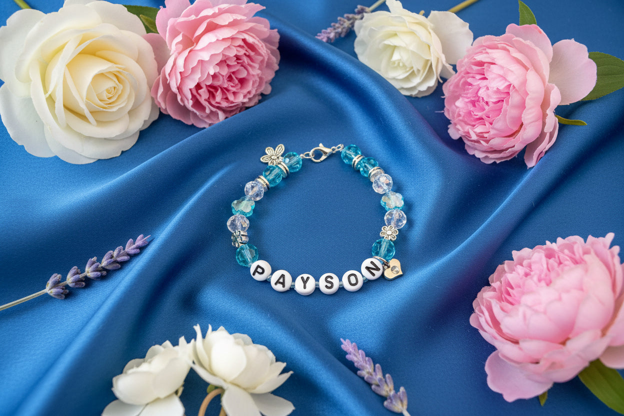 Bracelet with blue beads and 'PAYSON' name charm on a dark surface