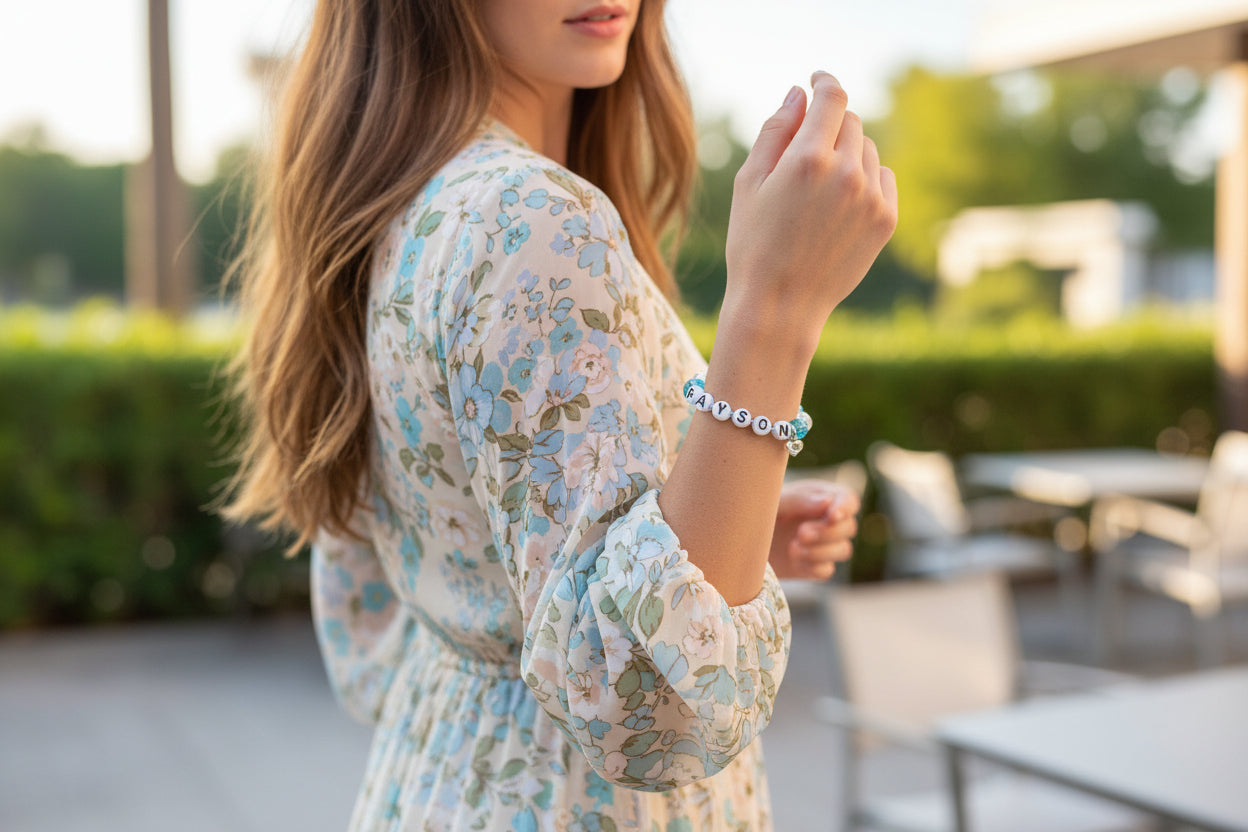 Bracelet with blue beads and personalized name charms on a dark surface