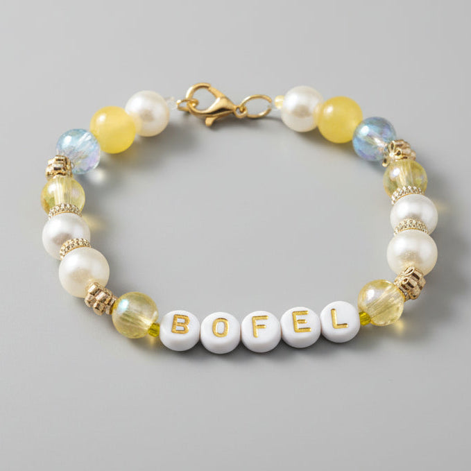 Beaded bracelet with gold accents on a dark textured background