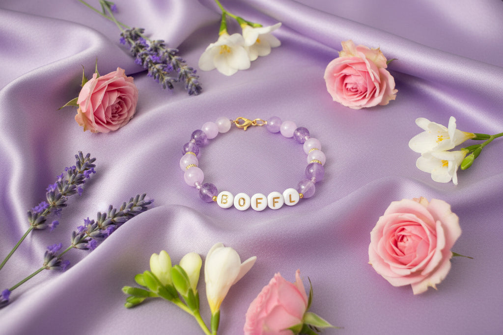 Bracelet with letter beads spelling 'BOFEL' on a dark background