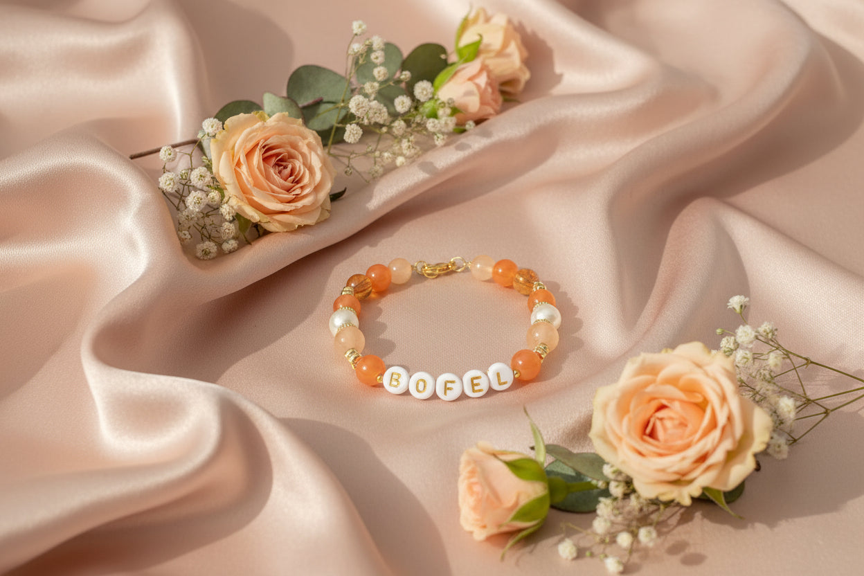Bracelet with letter beads spelling 'BOFEL' on a dark background