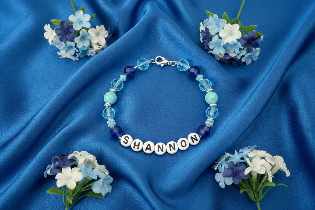 Bracelet with pink and clear beads and a nameplate on a black background