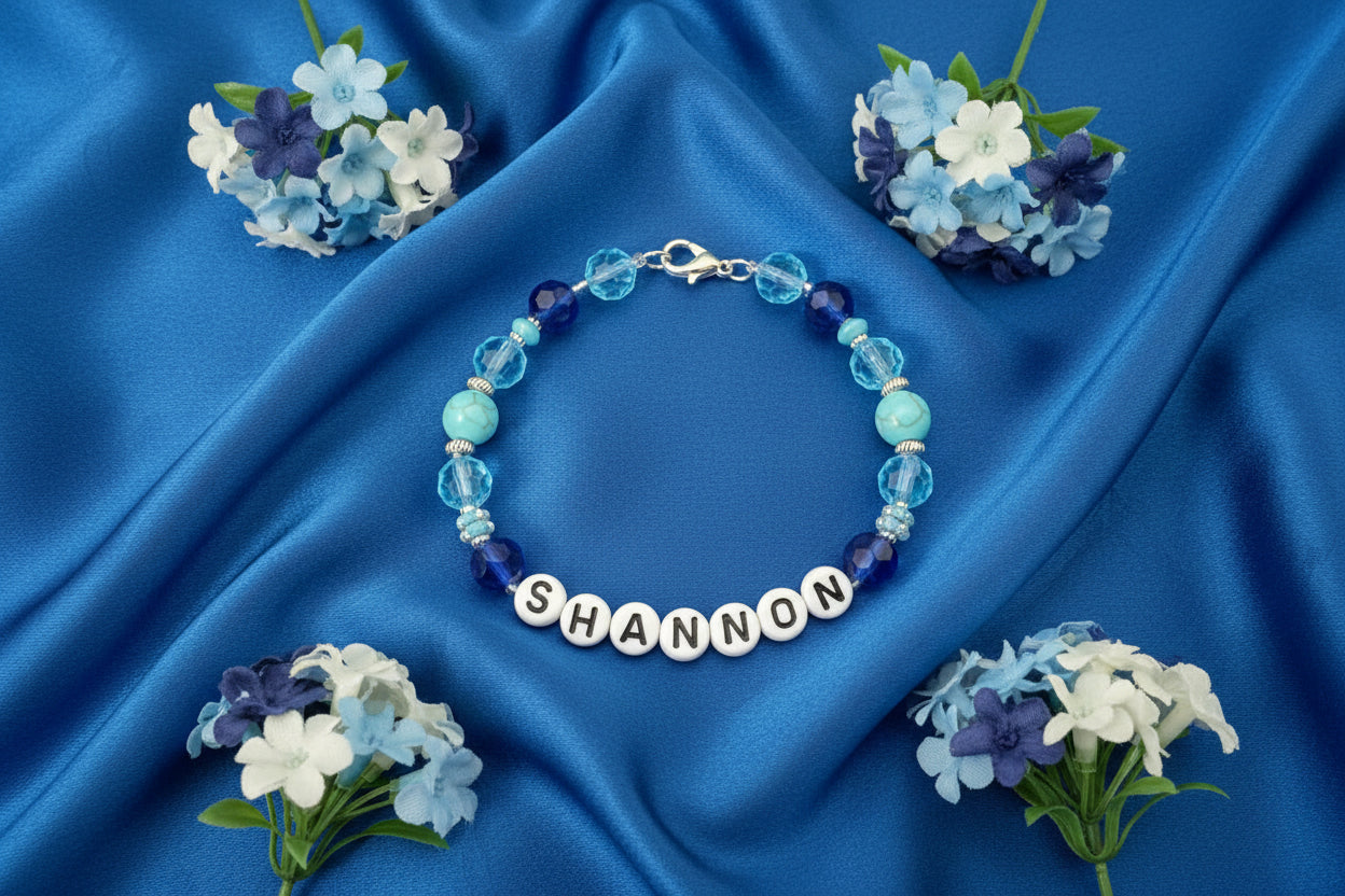 Bracelet with pink and clear beads and a nameplate on a black background