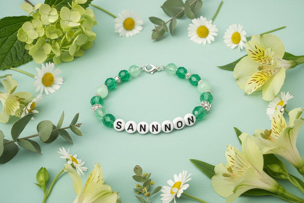 Bracelet with pink beads and 'SHANNON' nameplate on a dark background