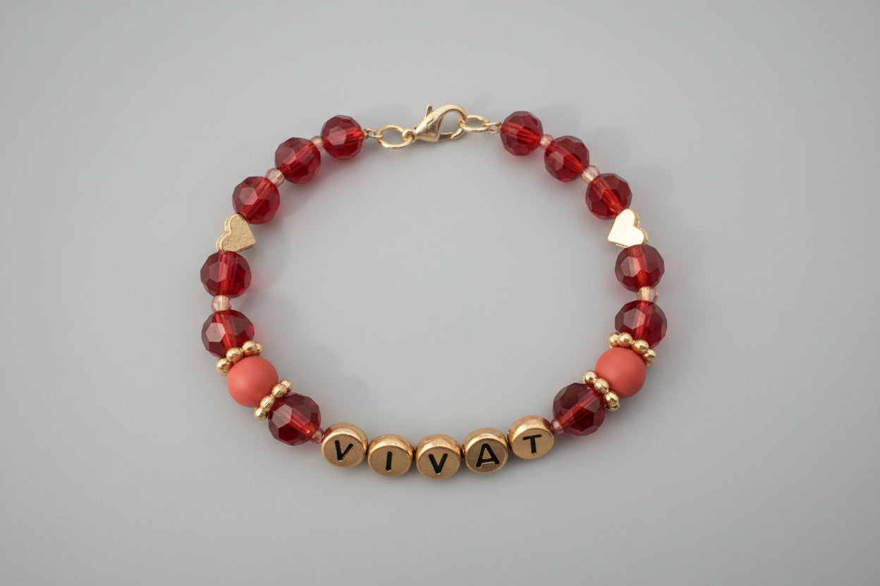 Bracelet with colorful beads and 'VIVAT' charm on a dark background