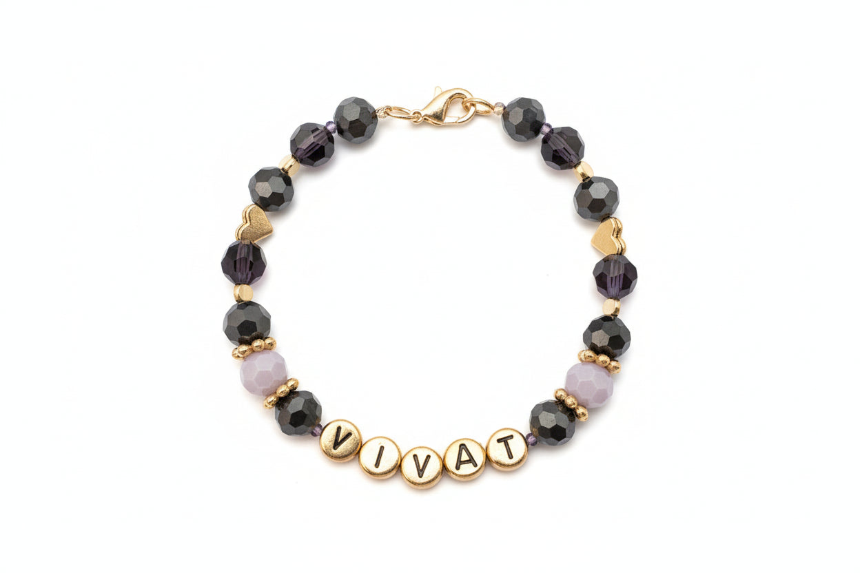 Bracelet with beads and gold letters spelling 'VIVA' on a dark background