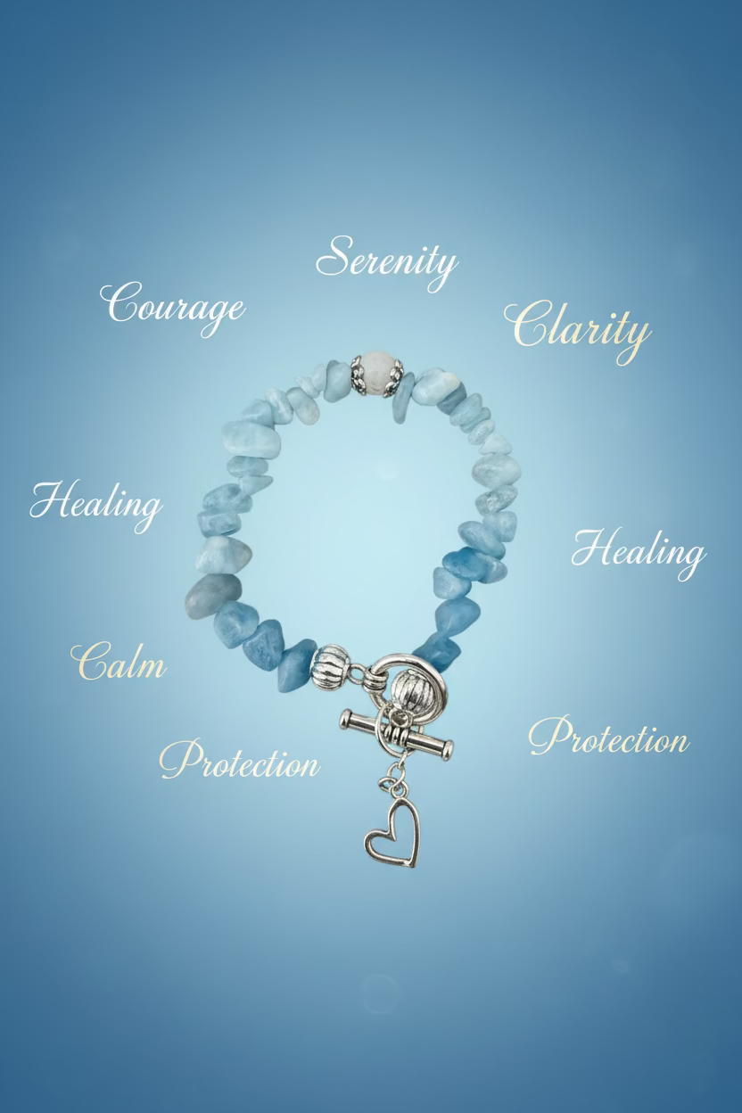 A beaded stretch bracelet made of light blue stone chips with a silver toggle clasp and dangling heart charm, displayed on a dark textured surface.