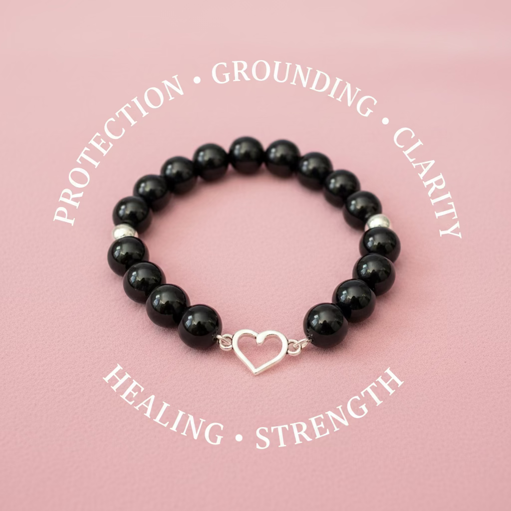A beaded bracelet made of glossy black round beads with a silver-tone open heart charm, displayed on a dark textured surface.