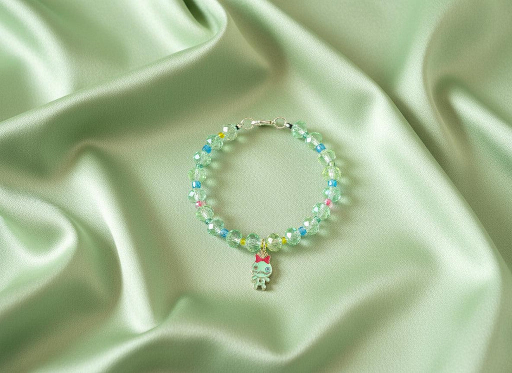 Beaded bracelet with a small charm on a dark textured surface