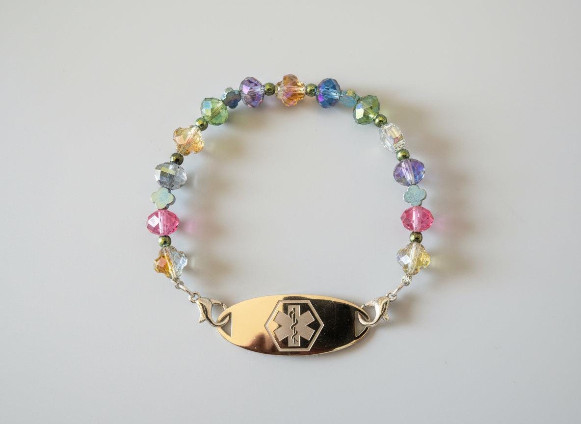 Multicolored beaded bracelet with an emergency medical symbol on a dark background