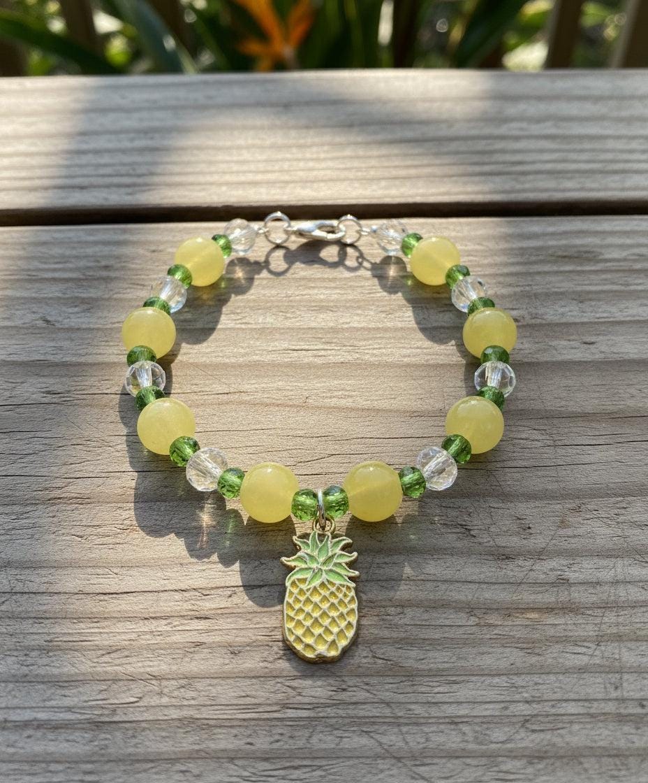 Beaded bracelet with pineapple charm on a dark textured background