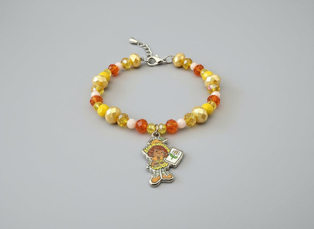 Beaded bracelet with a colorful charm on a black background