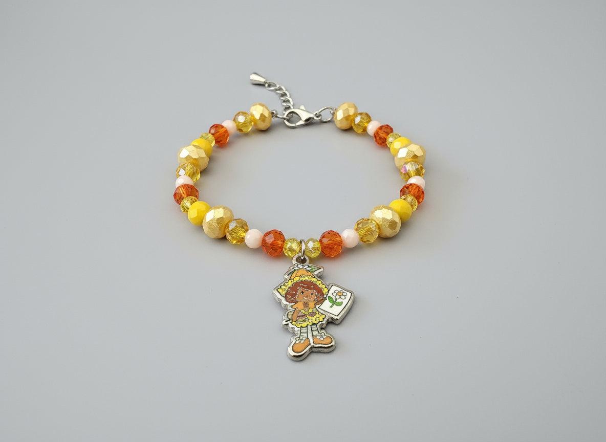 Beaded bracelet with a colorful charm on a black background