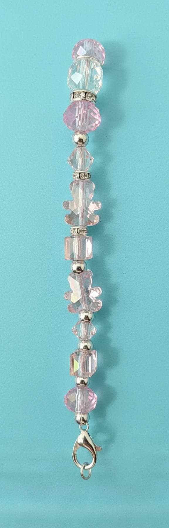 Bracelet with pink beads on a black mannequin hand