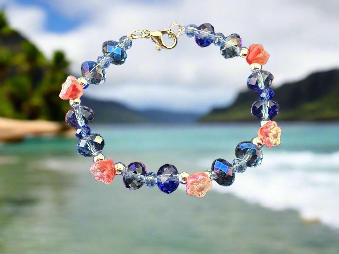Beaded bracelet with blue and pink flowers on a dark textured background